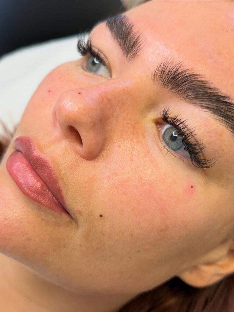 Close up of a woman's face featuring several small beauty marks on her skin.