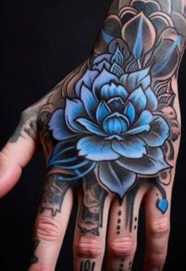 A large blue lotus flower tattoo intricately detailed on the back of a person's hand.