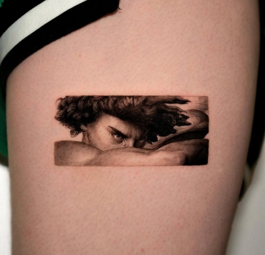 A realistic black and grey tattoo of a man's intense face on skin.